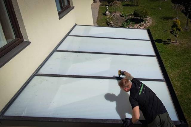 Fitting opal roof panels on an aluminium patio cover, aerial view