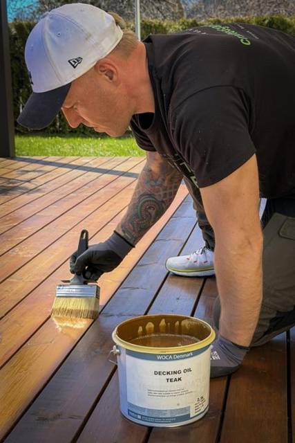 Oiling a hardwood deck with a wide brush