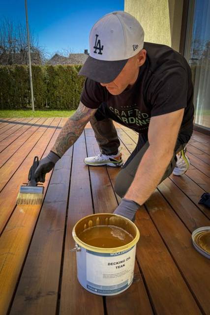 Brushing decking oil onto a timber deck