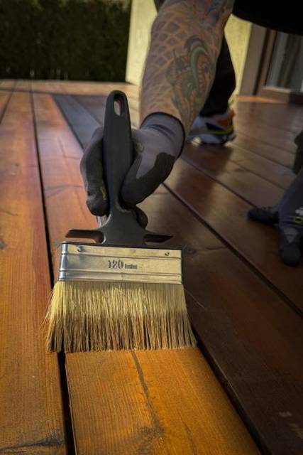 Decking oil brush on a hardwood board, close-up